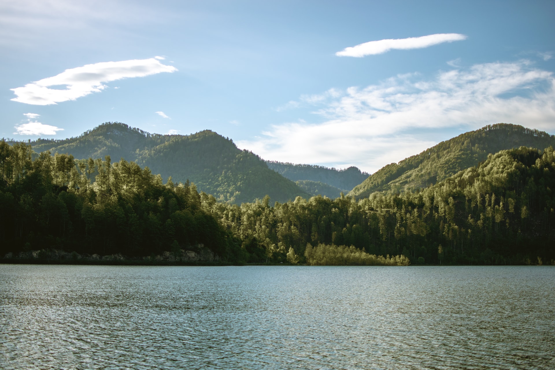 A calm lake bordered by hills of forest.